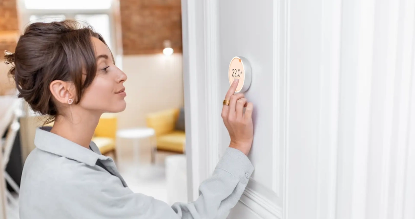 a person adjusting the thermostat